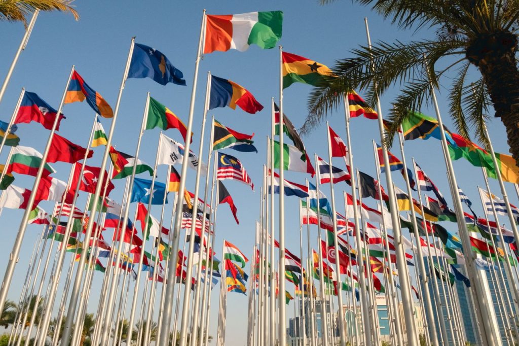 Mastering the First Impression: Your intriguing post title goes here Vibrant display of international flags near Doha's skyline, symbolizing global unity.